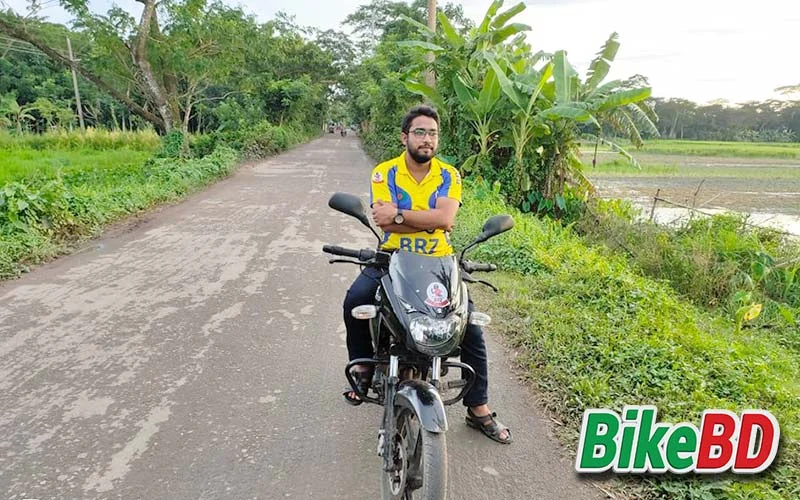 bajaj pulsar 150 black color with rider and headlight front tire