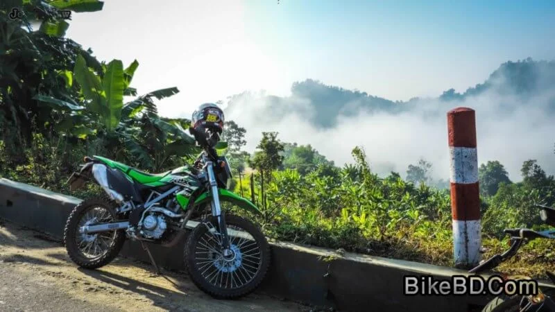 kawasaki klx 150bf green besides a hill